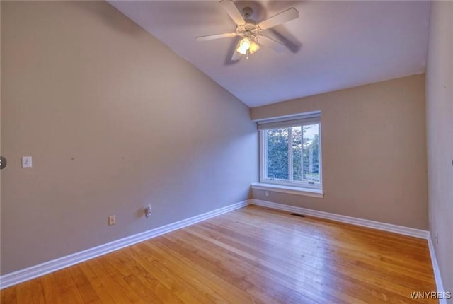 spare room featuring lofted ceiling, ceiling fan, and light wood-type flooring