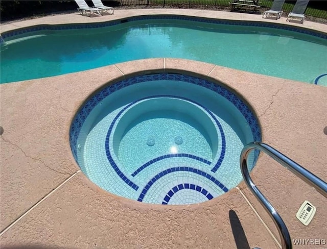 view of swimming pool featuring an in ground hot tub