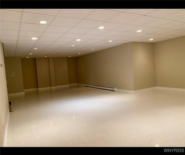 unfurnished room featuring a paneled ceiling and baseboard heating