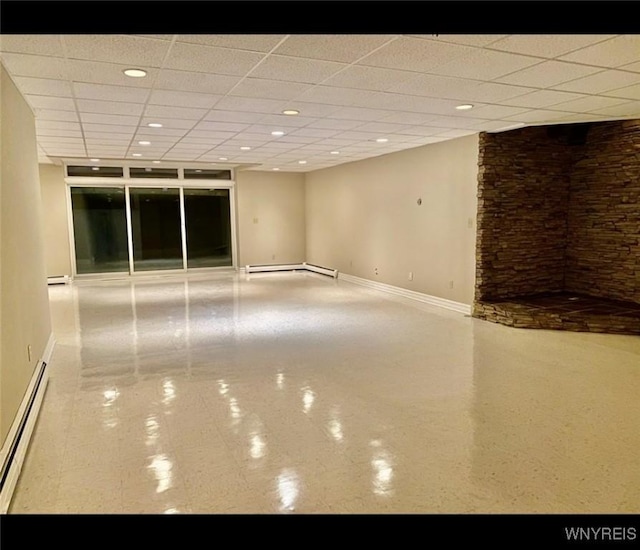 empty room with a drop ceiling and a baseboard heating unit