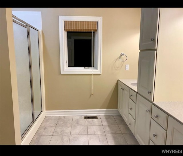 bathroom with walk in shower, tile patterned floors, and vanity