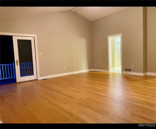 spare room with lofted ceiling and light hardwood / wood-style flooring