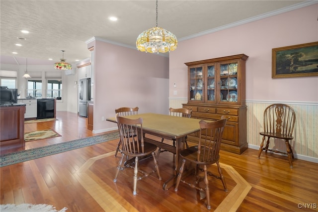 dining room with light hardwood / wood-style flooring and ornamental molding