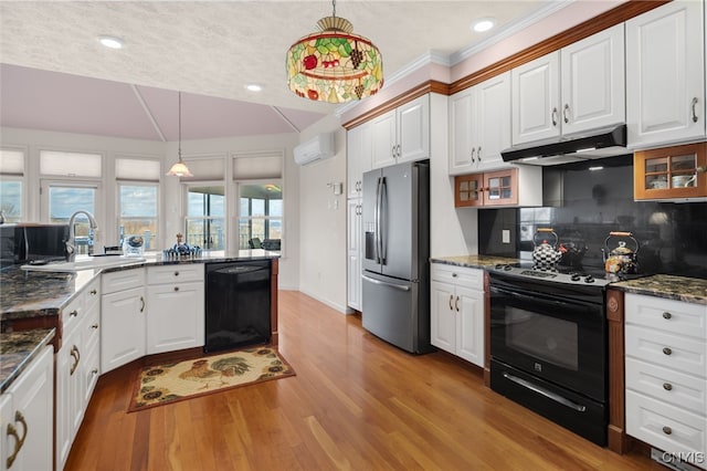 kitchen featuring backsplash, sink, black appliances, decorative light fixtures, and white cabinetry