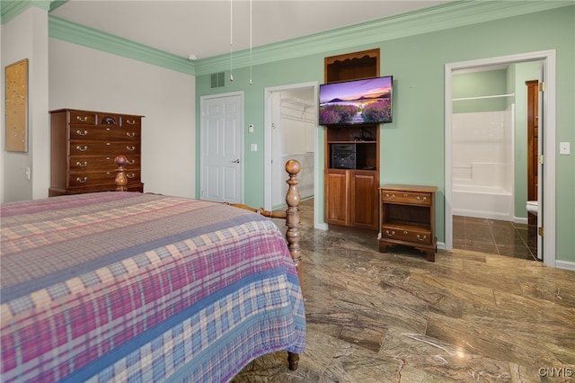 bedroom featuring ensuite bath, crown molding, and a closet