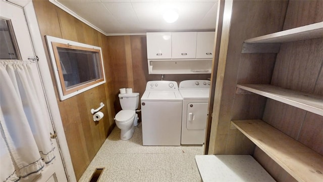 washroom featuring wood walls, washer and clothes dryer, and crown molding