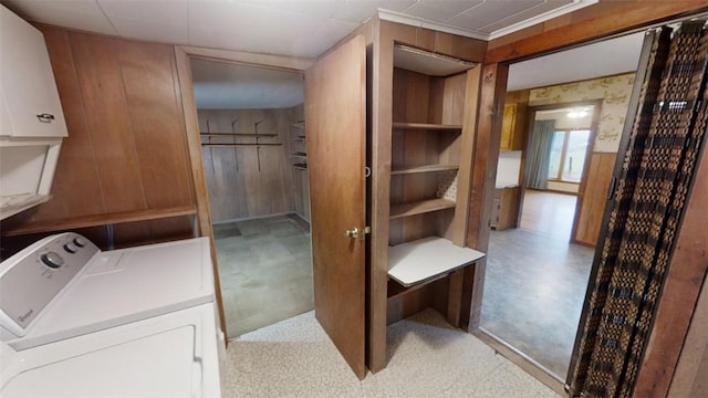 laundry area featuring light carpet, washer / dryer, cabinets, and wood walls