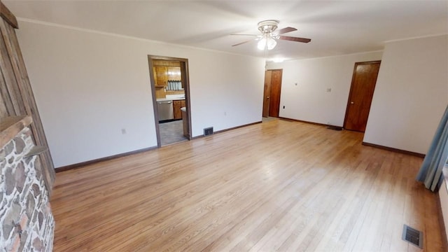 empty room with ceiling fan and light hardwood / wood-style flooring