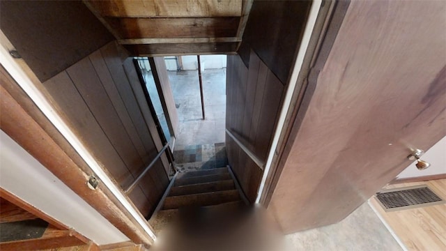 staircase with wood walls and hardwood / wood-style floors