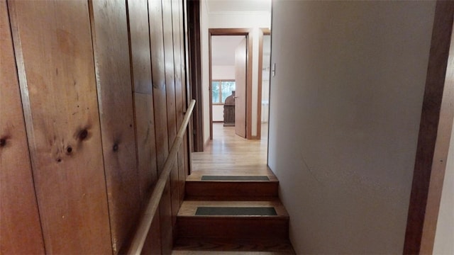 stairs featuring hardwood / wood-style flooring and wood walls