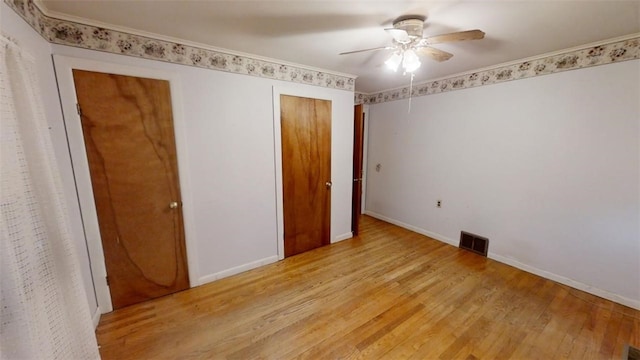 unfurnished bedroom with ceiling fan, crown molding, and light wood-type flooring