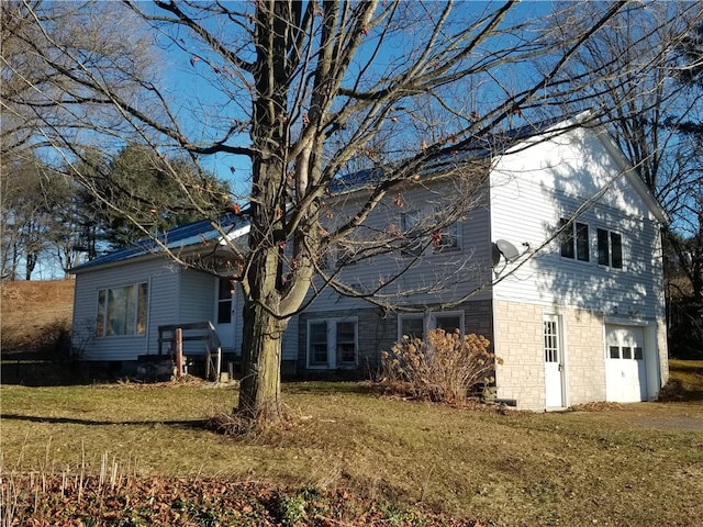 view of side of property with a garage and a lawn