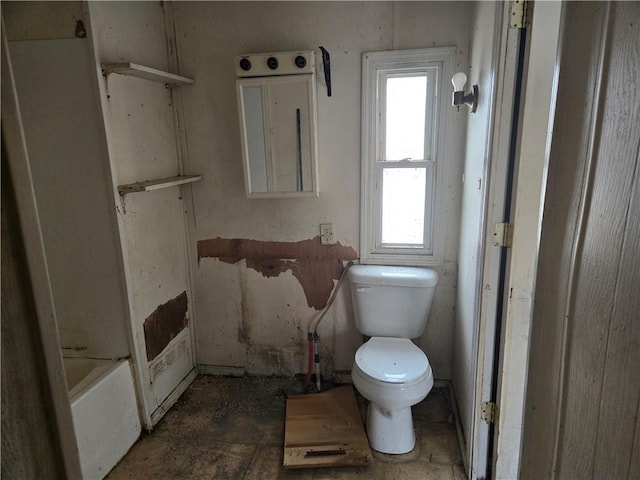 bathroom with toilet and a tub