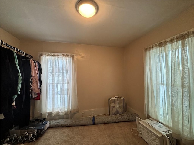 unfurnished bedroom featuring carpet floors and an AC wall unit