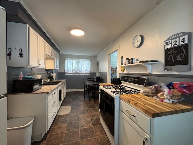 kitchen with white range with gas stovetop, white cabinetry, butcher block counters, and sink