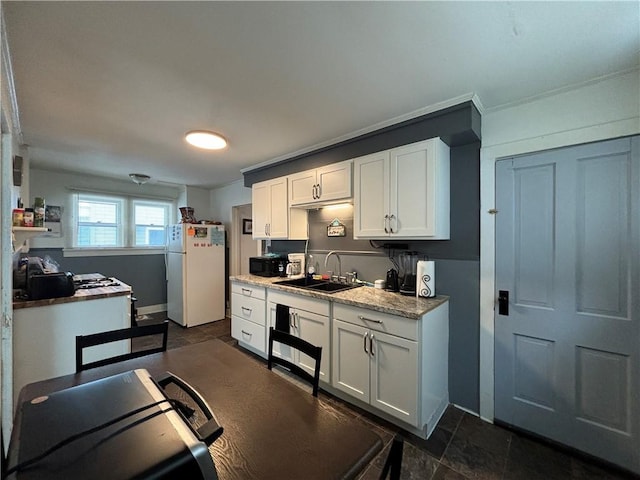 kitchen featuring light stone counters, sink, white cabinets, and white refrigerator