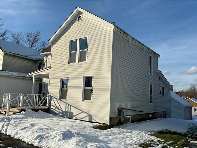 view of snow covered rear of property