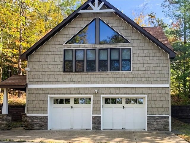 4555 Davies Rd, Hector, NY 14818 - view of side of home featuring stone siding, driveway, and an attached garage