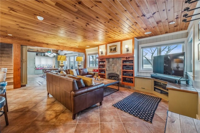 tiled living room with wood walls, a tiled fireplace, a healthy amount of sunlight, and wood ceiling