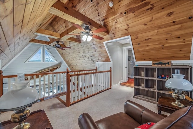 interior space featuring light colored carpet, ceiling fan, wooden walls, lofted ceiling with beams, and wooden ceiling