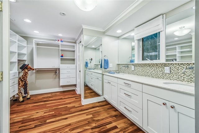 bathroom with tasteful backsplash, vanity, ornamental molding, and hardwood / wood-style flooring