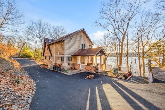 view of side of property featuring a water view and central air condition unit