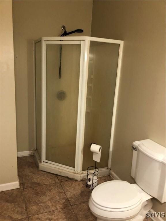 bathroom with a shower with shower door and toilet