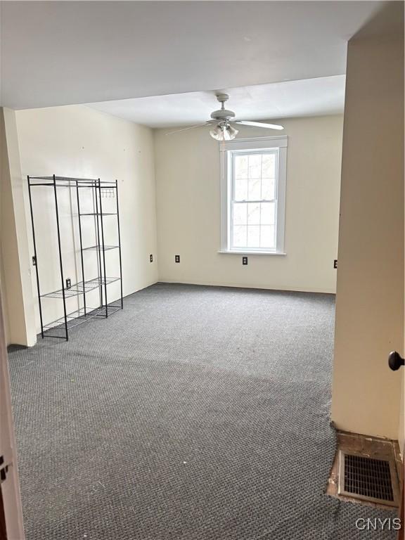 carpeted spare room with ceiling fan