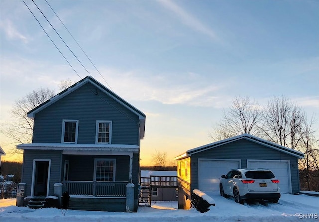 view of front of home with an outbuilding, covered porch, and a garage