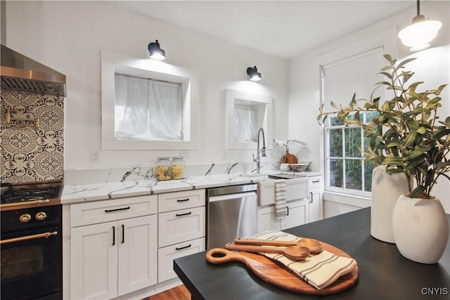 kitchen with decorative backsplash, light stone countertops, stainless steel appliances, decorative light fixtures, and white cabinets