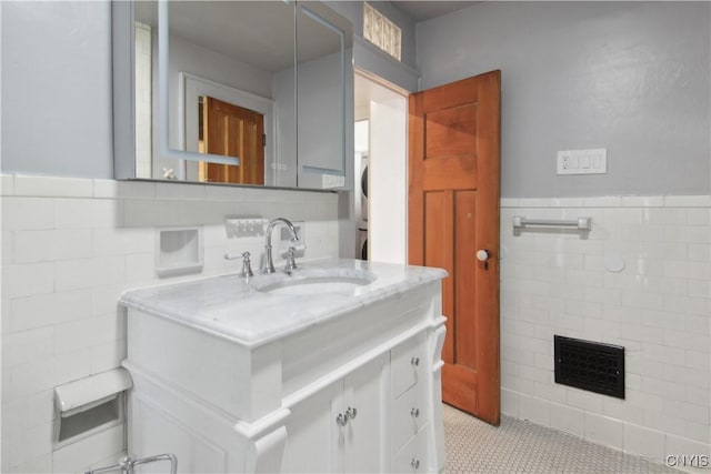 bathroom featuring a fireplace, vanity, tile patterned floors, and tile walls