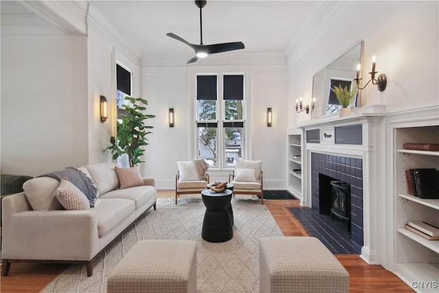 living room featuring wood-type flooring, ceiling fan, and ornamental molding