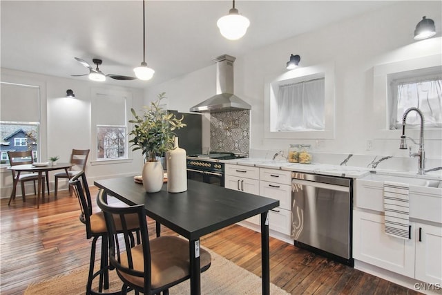 kitchen with white cabinets, appliances with stainless steel finishes, dark hardwood / wood-style floors, and wall chimney exhaust hood