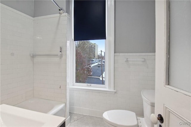 bathroom with tile patterned flooring, tile walls, and toilet