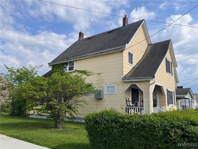 view of home's exterior featuring a lawn and covered porch