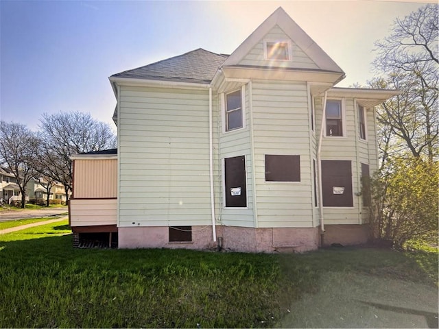 property exterior at dusk featuring a yard