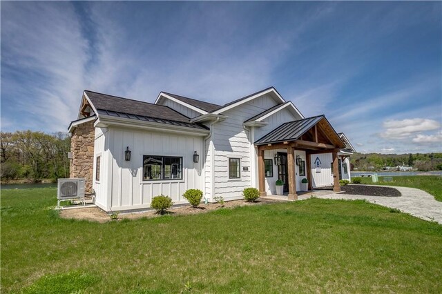 205 Charles Herrmann Way Unit 205, Milo, NY 14527 - exterior space featuring board and batten siding, a standing seam roof, metal roof, a lawn, and ac unit