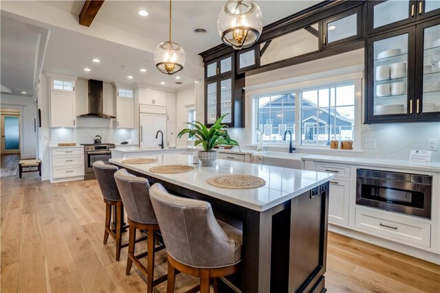 205 Charles Herrmann Way Unit 205, Milo, NY 14527 - kitchen featuring wall chimney range hood, built in appliances, a sink, and light countertops