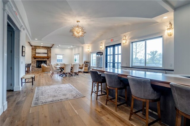 205 Charles Herrmann Way Unit 205, Milo, NY 14527 - dining space with a fireplace, wood finished floors, lofted ceiling, an inviting chandelier, and recessed lighting