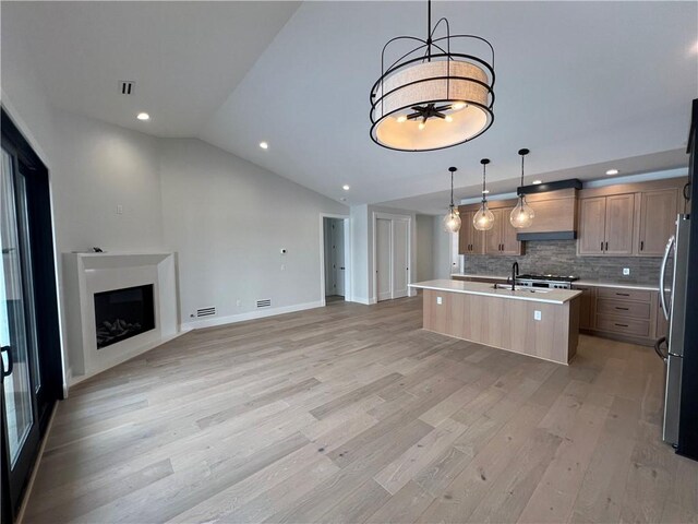 205 Charles Herrmann Way Unit 205, Milo, NY 14527 - kitchen featuring freestanding refrigerator, open floor plan, an island with sink, premium range hood, and light wood finished floors