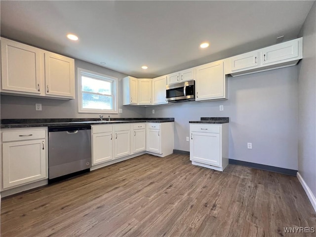 kitchen featuring white cabinetry, hardwood / wood-style flooring, and appliances with stainless steel finishes