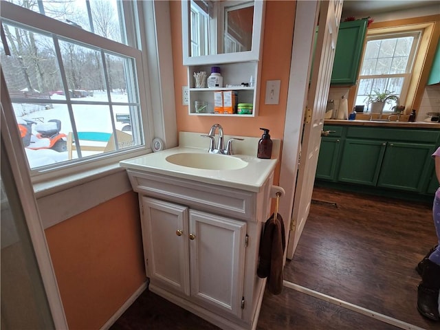 bathroom featuring hardwood / wood-style flooring, a healthy amount of sunlight, and sink