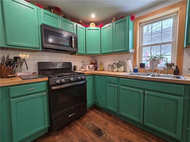 kitchen with dark hardwood / wood-style floors, black gas stove, sink, and green cabinetry