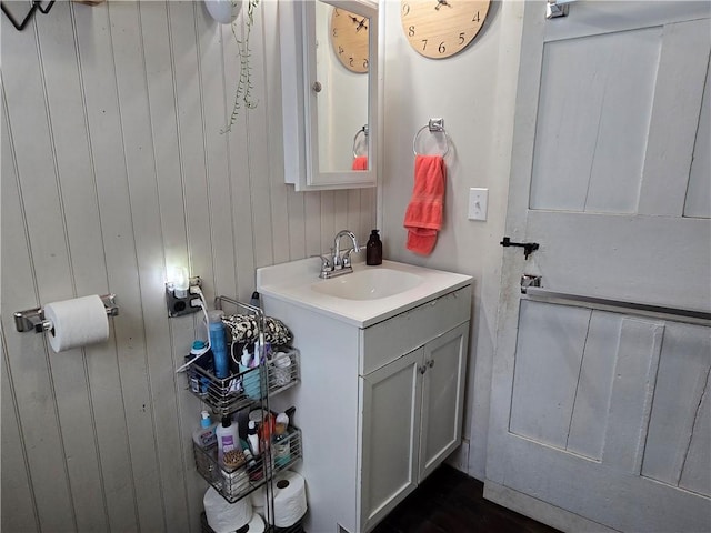 bathroom with vanity and wood walls