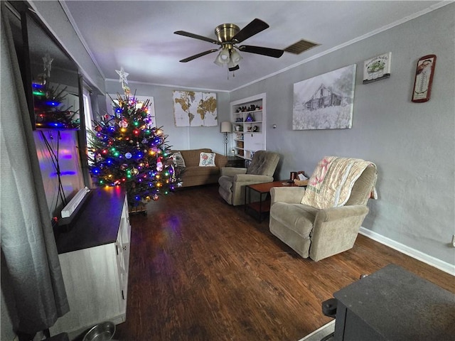 living room with ceiling fan, dark hardwood / wood-style flooring, built in features, and crown molding