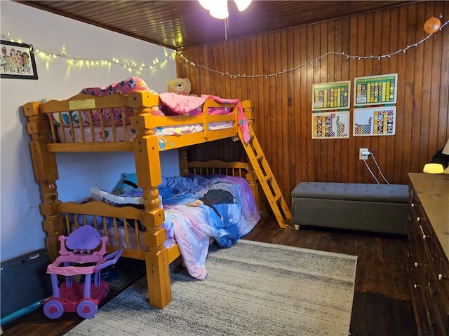 bedroom featuring hardwood / wood-style floors and wood walls