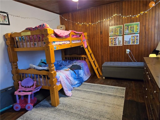 bedroom featuring hardwood / wood-style floors and wood walls