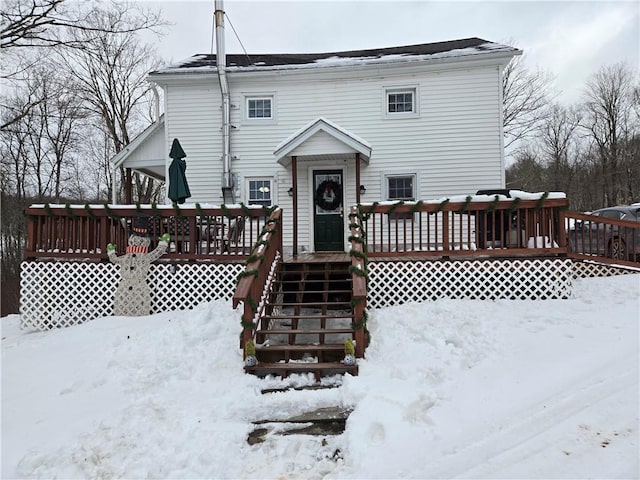 snow covered house featuring a wooden deck