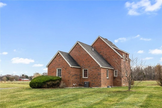 view of side of property with a lawn and cooling unit