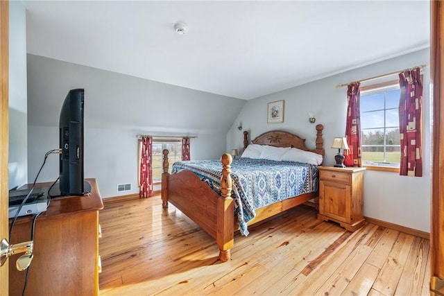 bedroom featuring light wood-type flooring and lofted ceiling